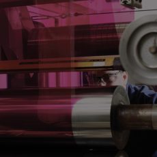 Coating services person examining coating rollers 1920